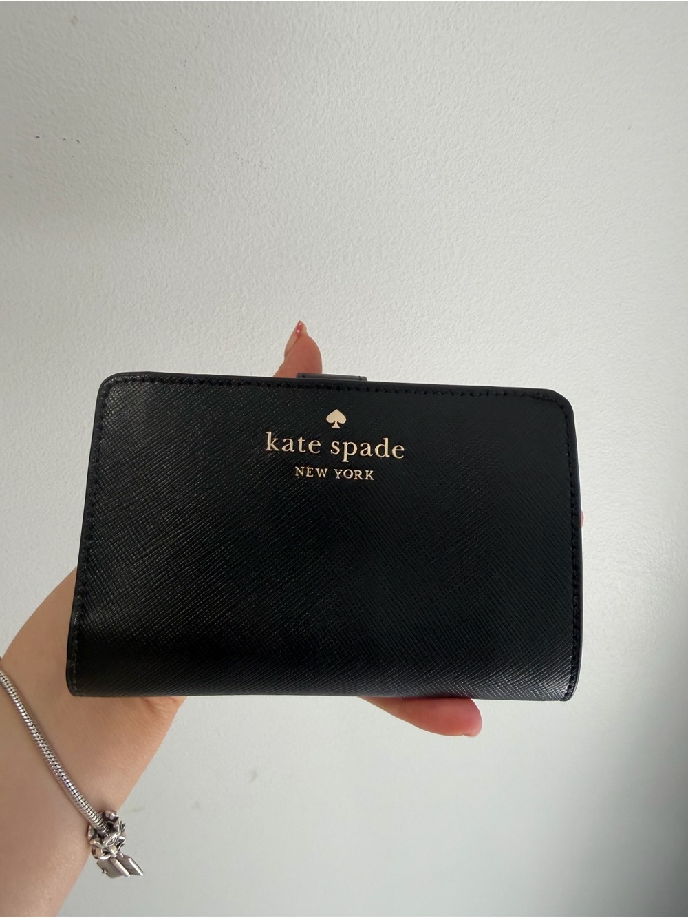 kate spade black compact saffiano wallet with gold logo